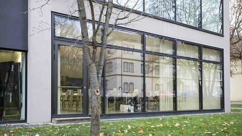 Blick von außen auf einen Lehrsaal durch eine Fensterfront