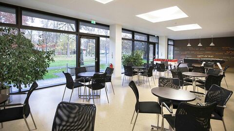 Raum mit runden Tischen und Stühlen