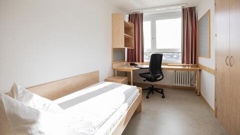 Internatszimmer Zimmer mit Einzelbett, Schrank, Schreibtisch und Stuhl