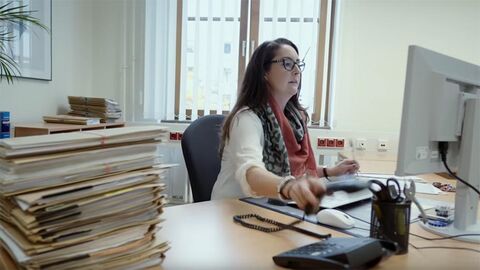 Rechtspflegerin bei der Arbeit Rechtspflegerin sitzt an einem Schreibtisch.