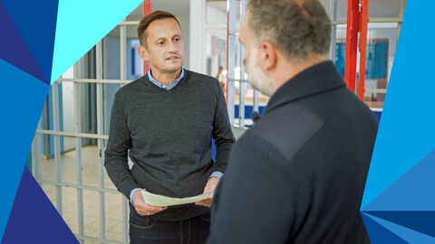 Vollzugsmitarbeiter im Gespräch in einer Vollzugsanstalt.