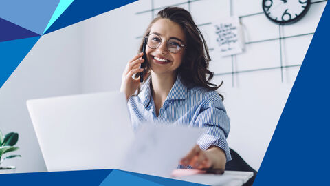 Junge Frau am Schreibtisch, hält Dokumente vor sich und telefoniert