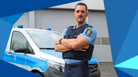 Ein Vollzugsbeamter in Uniform steht vor einem Justizfahrzeug