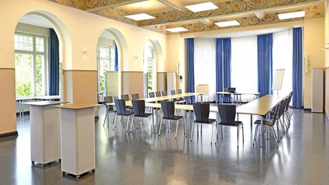 Innenansicht mit vielen Fenstern, Tischen und Stühlen