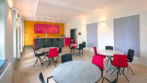 Seminarraum mit vier runden Tischen und Stühlen