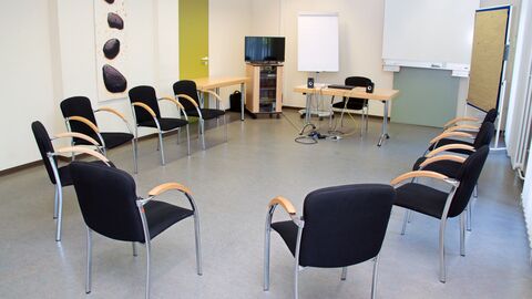 Seminarraum mit Schreibtisch und Stuhlkreis