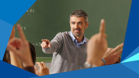 Lehrer steht vor seinen Schülern, die sich melden, und zeigt auf jemanden.